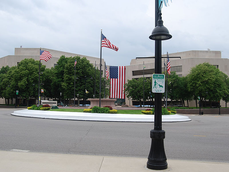 St. Clair County, Illinois, featuring American flags and a landscaped roundabout in front of a