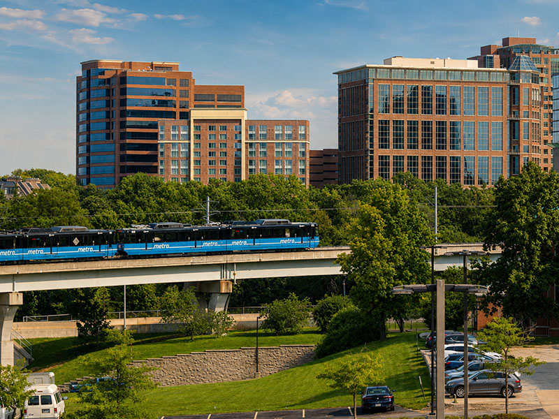St. Louis County cityscape and MetroLink train representing transportation and legal services.